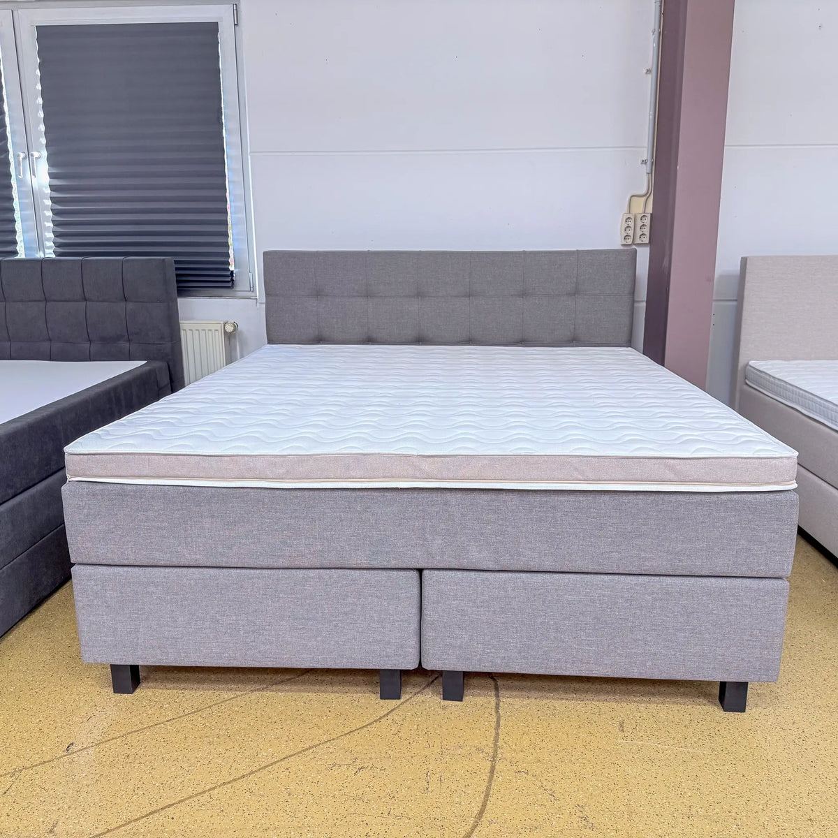 Boxspringbett Mats 180x200 in Taupe mit rechteckig gestepptem Kopfteil, Kaltschaumtopper und schwarzen Holzfüßen, Frontansicht