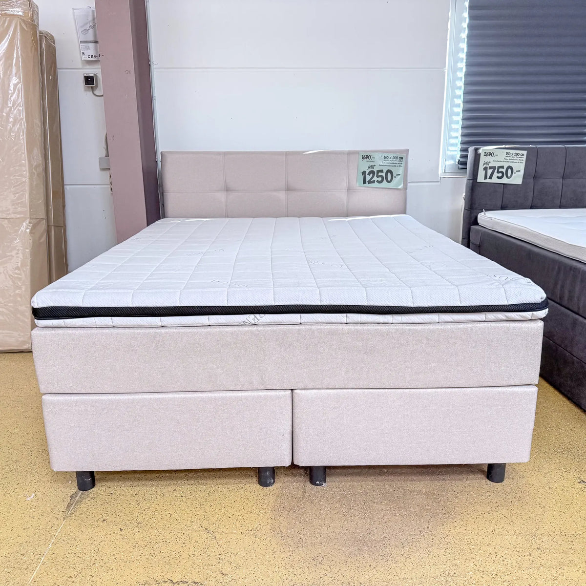 Boxspringbett Ben 160x200 in Beige mit rechteckig gestepptem Kopfteil, Visco-Komfortschaumtopper und schwarzen Holzfüßen, Frontansicht