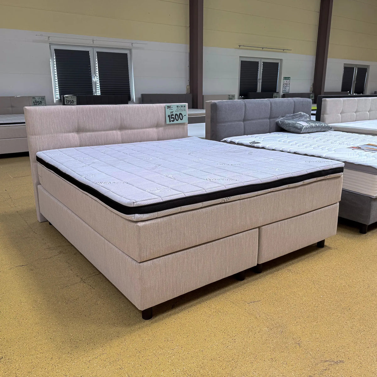 Boxspringbett Theo 180x200 in Beige mit gepolstertem Kopfteil, Visco-Komfortschaumtopper und runden schwarzen Holzfüßen, Frontansicht