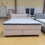 Boxspringbett Theo 180x200 in Beige mit fein gewebtem Stoffbezug, horizontal gestepptem Kopfteil und Visco-Komfortschaumtopper, schräge Vorderansicht